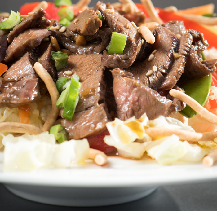 This hearty Asian Steak Salad is loaded with healthy vegetables, tender grilled steak and topped with a dressing that'll knock your socks off! | The Recipe Wench